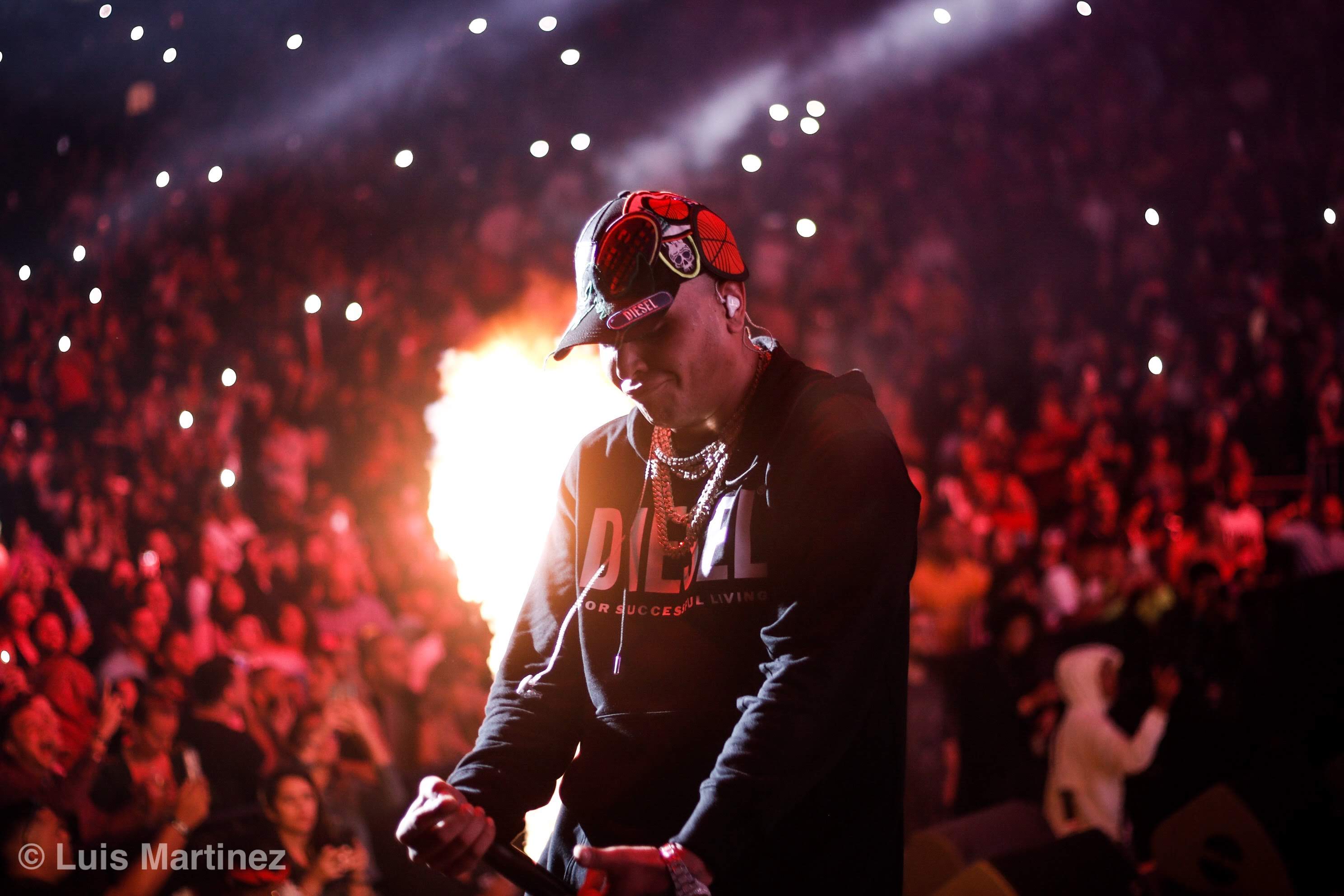 Artista en concierto frente a una multitud iluminada en rojo